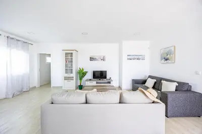a white living room with a couch and a tv at Azur & Bellevue du Caniço by YOUR KEY in Caniço