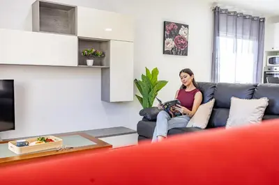 a woman sitting on a couch in a living room at Azur & Bellevue du Caniço by YOUR KEY in Caniço