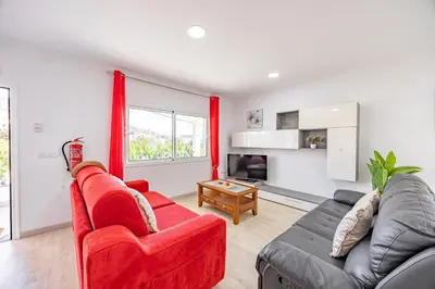 a living room with a red couch and a table at Azur & Bellevue du Caniço by YOUR KEY in Caniço