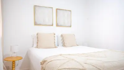 a bedroom with a white bed with two pictures on the wall at Solar do Mar by LovelyStay in Funchal