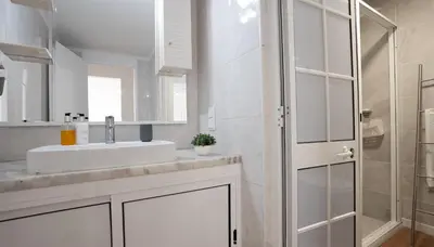 a white bathroom with a sink and a shower at Solar do Mar by LovelyStay in Funchal