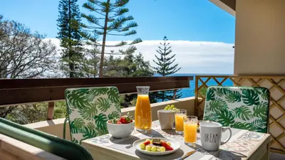 a table with a bowl of fruit and juice on a balcony at Solar do Mar by LovelyStay in Funchal