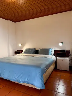 a bedroom with a large bed with blue sheets at Habitación con estacionamiento y baño privado in Funchal
