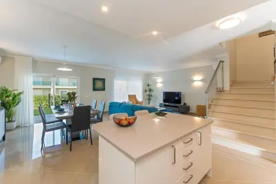 a kitchen and living room with a table and a blue couch at Casa Eva, golfe, conforto, piscina e spa in Lagos