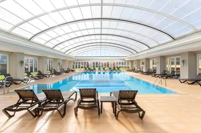 a large swimming pool with chairs and a glass ceiling at Casa Eva, golfe, conforto, piscina e spa in Lagos