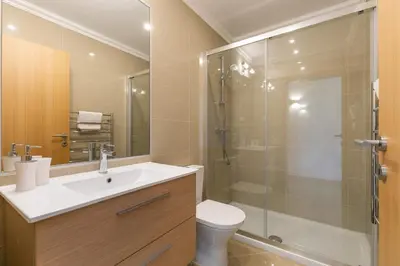 a bathroom with a shower and a toilet and a sink at Casa Eva, golfe, conforto, piscina e spa in Lagos