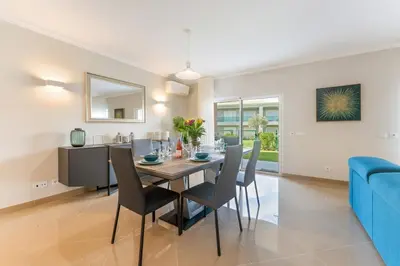 a dining room and living room with a table and chairs at Casa Eva, golfe, conforto, piscina e spa in Lagos