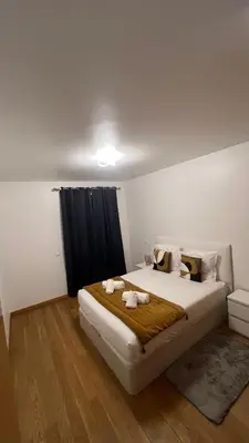 a bedroom with a large bed with two towels on it at Paradisus guest house in Caniço