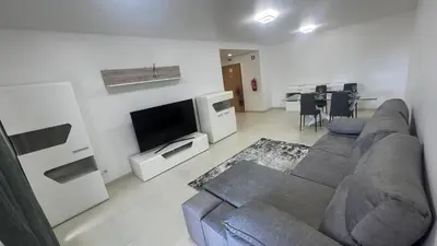a living room with a couch and a flat screen tv at Paradisus guest house in Caniço
