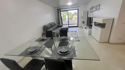 a dining table and chairs in a living room at Paradisus guest house in Caniço