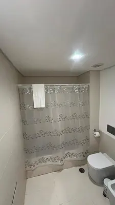 a bathroom with a shower curtain and a toilet at Paradisus guest house in Caniço