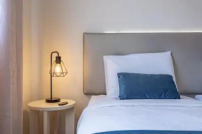 a bedroom with a large black bed and wooden floors at Machico Apt Moderno Familias ou Grupos in Machico