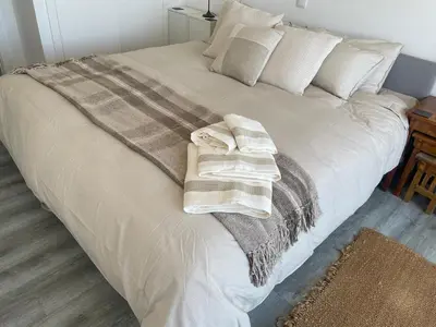 a large white bed with two towels on it at Casa Dourada - Golden Beach Apt in Budens