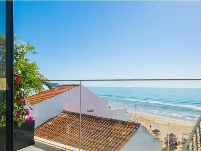 a view of the beach from the balcony of a house at Casa Dourada - Golden Beach Apt in Budens