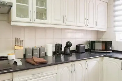 a kitchen with white cabinets and a black counter top at Gorete Apartment by Mth in Funchal