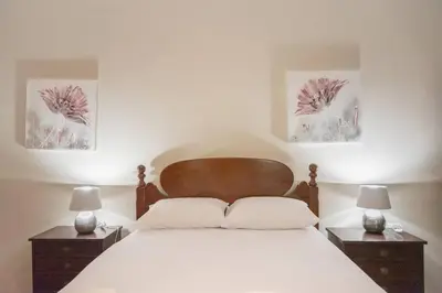 a bedroom with a white bed with two night stands at Gorete Apartment by Mth in Funchal