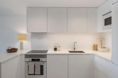 a white kitchen with white cabinets and a sink at Acqua Residence IV by An Island Apart in Funchal
