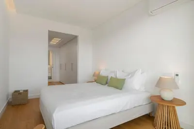 a white bedroom with a white bed and a table at Acqua Residence IV by An Island Apart in Funchal