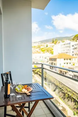 a table with a plate of food on a balcony at Maderia Emotions I, By OP in Funchal