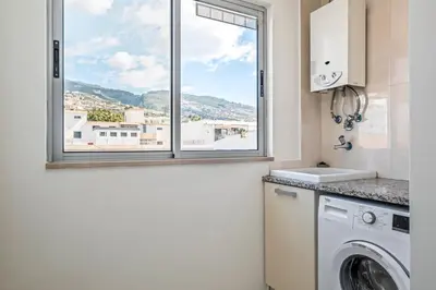 a laundry room with a window and a washing machine at Maderia Emotions I, By OP in Funchal