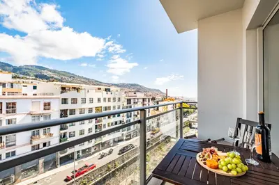a bowl of fruit on a balcony with a view of a city at Maderia Emotions I, By OP in Funchal