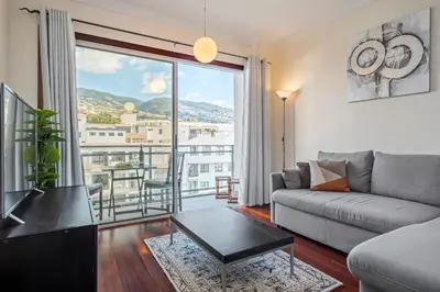 a living room with a couch and a large window at Maderia Emotions I, By OP in Funchal