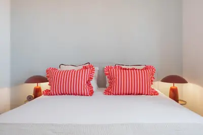 a bed with red and white pillows and two lamps at Casa Afonso by An Island Apart in Santana