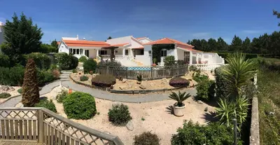 a house with a landscaping in front of it at Casa Borboleta Gepflegte Villa mit Meerblick, großem Garten und Pool, Traumlage in Aljezur