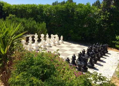 a giant chess set on avisor in a garden at Casa Borboleta Gepflegte Villa mit Meerblick, großem Garten und Pool, Traumlage in Aljezur