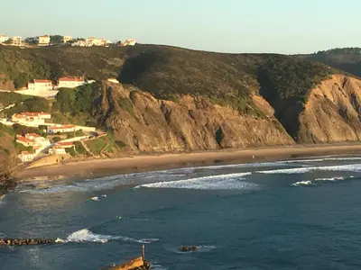 a view of a beach with houses on a mountain at Casa Borboleta Gepflegte Villa mit Meerblick, großem Garten und Pool, Traumlage in Aljezur