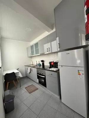 a kitchen with a white refrigerator and a table at Cc39-Q2 in Funchal