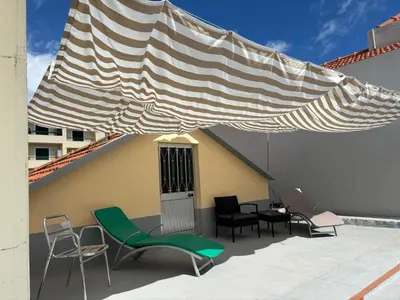 a patio with chairs and awning on a building at Cc39-Q2 in Funchal