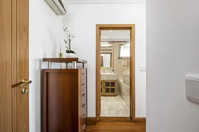 a bathroom with a wooden door and a mirror at Serenity Solace by Homie in Funchal