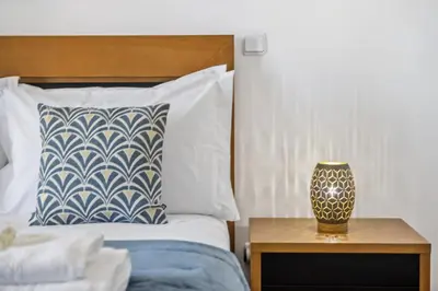 a bed with a pillow and a table with a lamp at Serenity Solace by Homie in Funchal