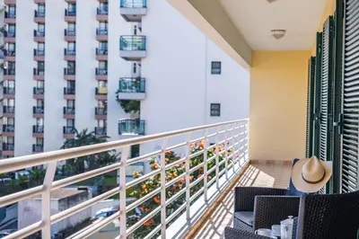 a balcony with chairs and a building at Serenity Solace by Homie in Funchal
