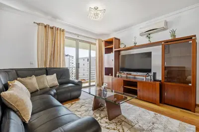 a living room with a leather couch and a television at Serenity Solace by Homie in Funchal