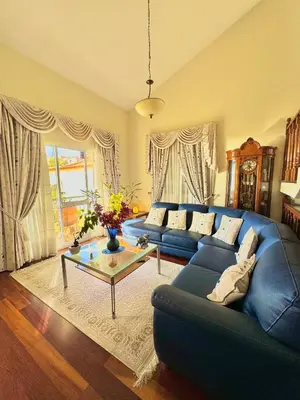 a living room with a blue couch and a table at The Sun Edge House in Ponta do Sol