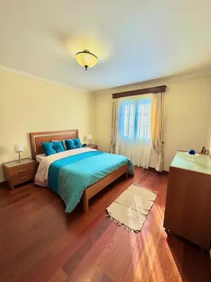 a bedroom with a bed with blue pillows and a window at The Sun Edge House in Ponta do Sol