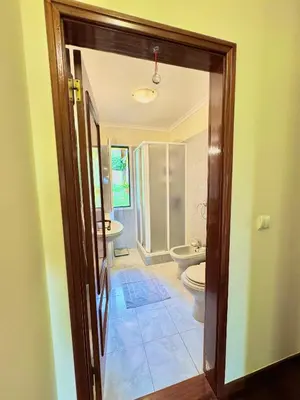 a bathroom with two sinks and a toilet and a doorway at The Sun Edge House in Ponta do Sol