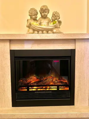 a fireplace with two statues of children on top of it at The Sun Edge House in Ponta do Sol