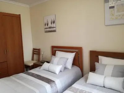a bedroom with two beds with white pillows at The Sun Edge House in Ponta do Sol