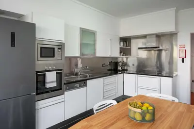 a kitchen with a wooden table with a bowl of fruit at Amparo II by An Island Apart in Funchal