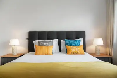 a bedroom with a large bed with colorful pillows at Amparo II by An Island Apart in Funchal