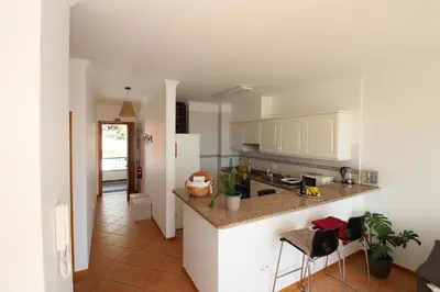 a kitchen with white cabinets and a counter top at Musa Apartment in Madalena do Mar