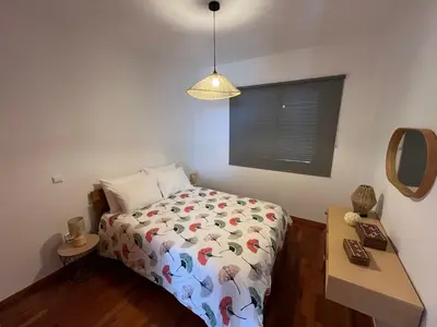 a small bedroom with a bed and a mirror at Musa Apartment in Madalena do Mar