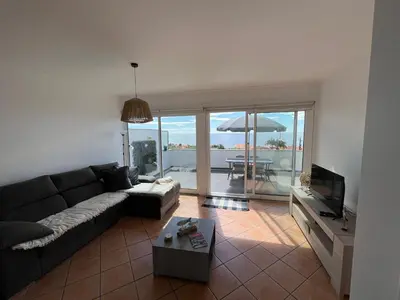 a living room with a couch and a table with an umbrella at Musa Apartment in Madalena do Mar