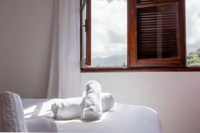 a stuffed animal sitting on a bed in front of a window at Silva Retreat Villa in São Jorge
