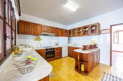 a kitchen with wooden cabinets and a counter top at Silva Retreat Villa in São Jorge