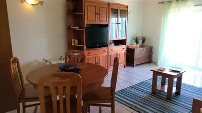 a living room with a table and a kitchen with a television at Apartamento Amalita em Burgau in Burgau