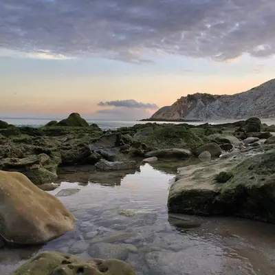 a beach with rocks and water and the ocean at Apartamento Amalita em Burgau in Burgau